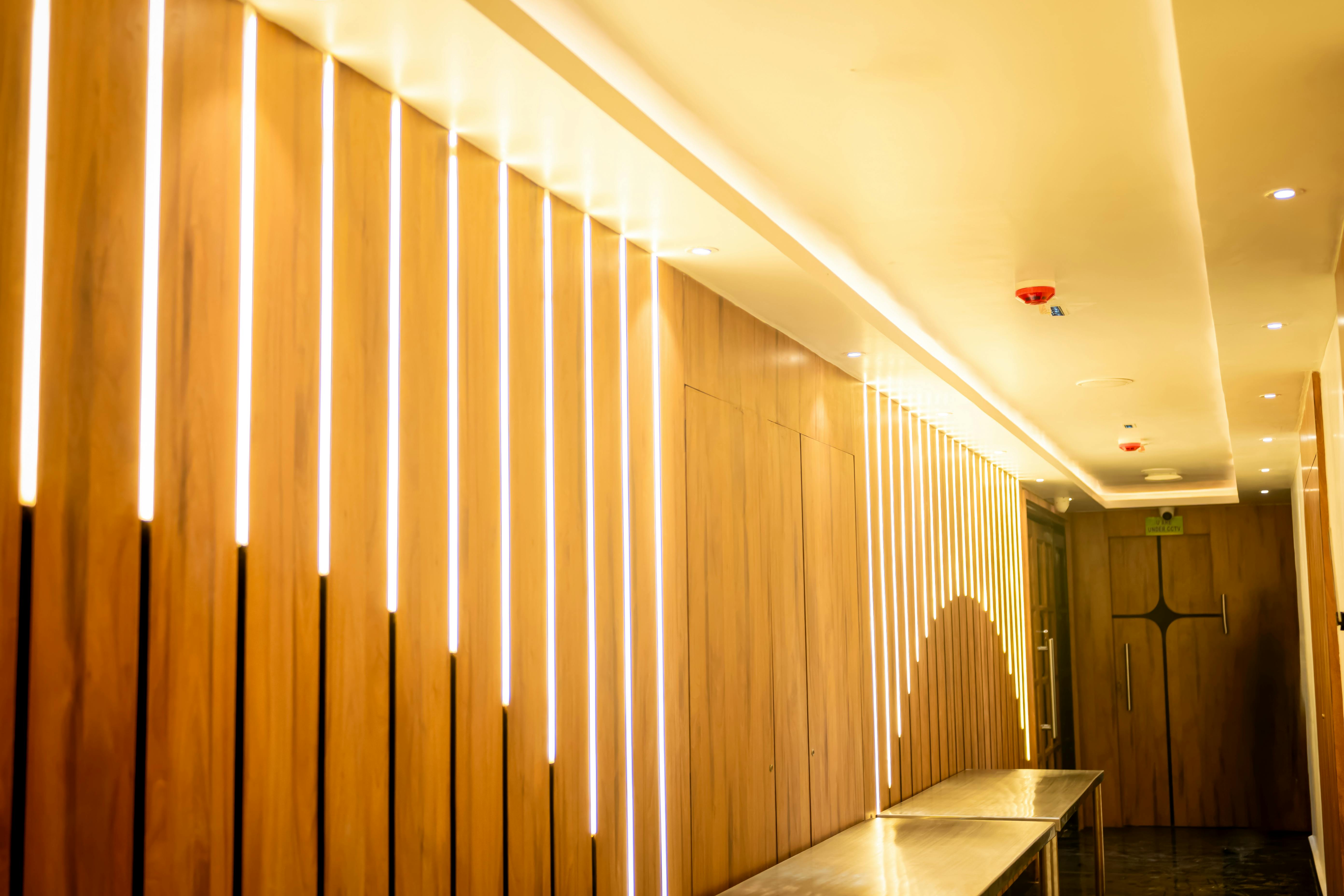 Service Elegant hallway with modern wood paneling and ambient lighting in a hotel setting.