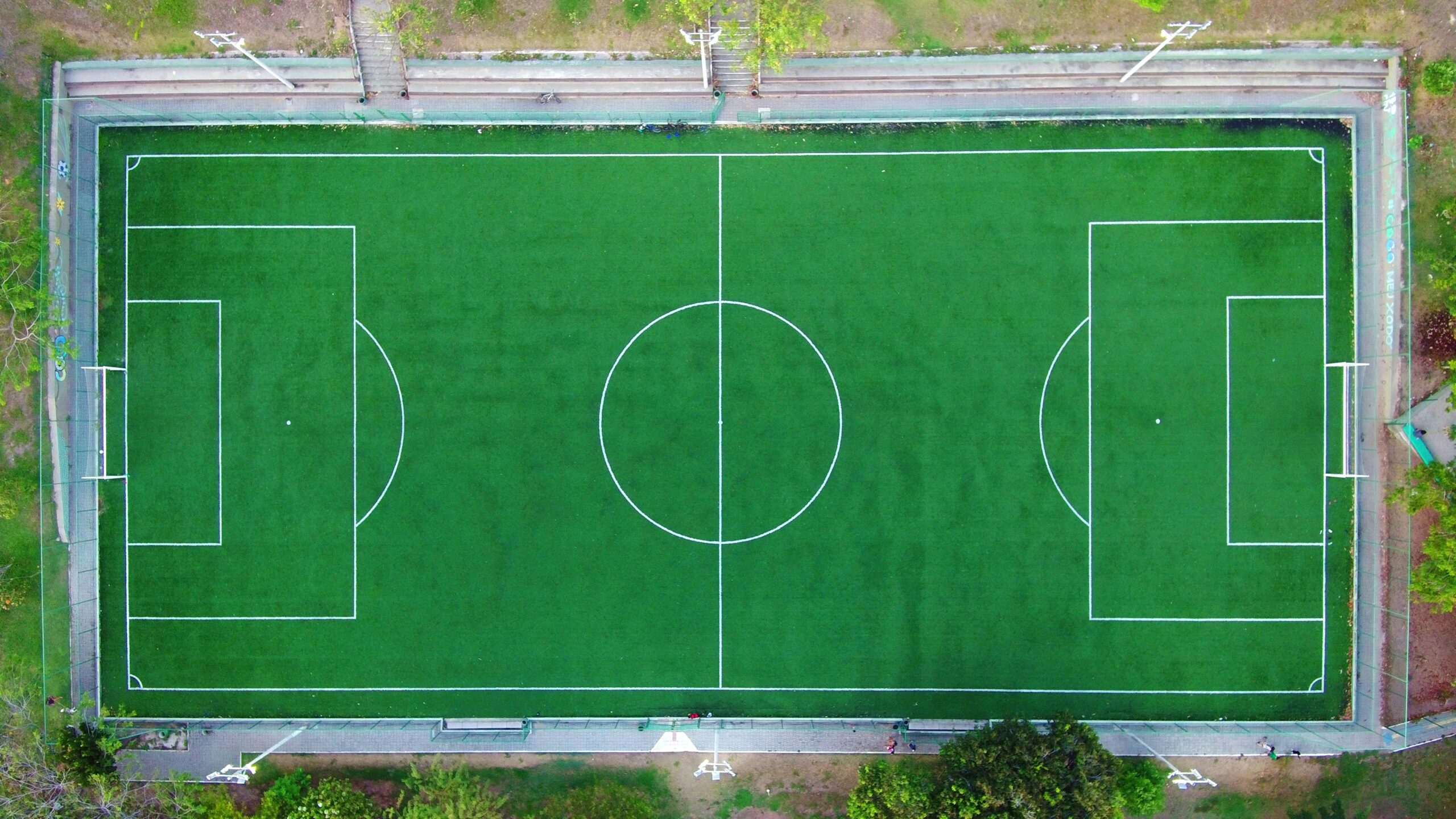 Service Bright aerial shot of an empty green soccer field with clearly marked lines.